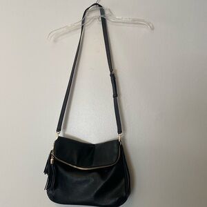 A black, roomy bag, nicely finished with fringes on the sides.